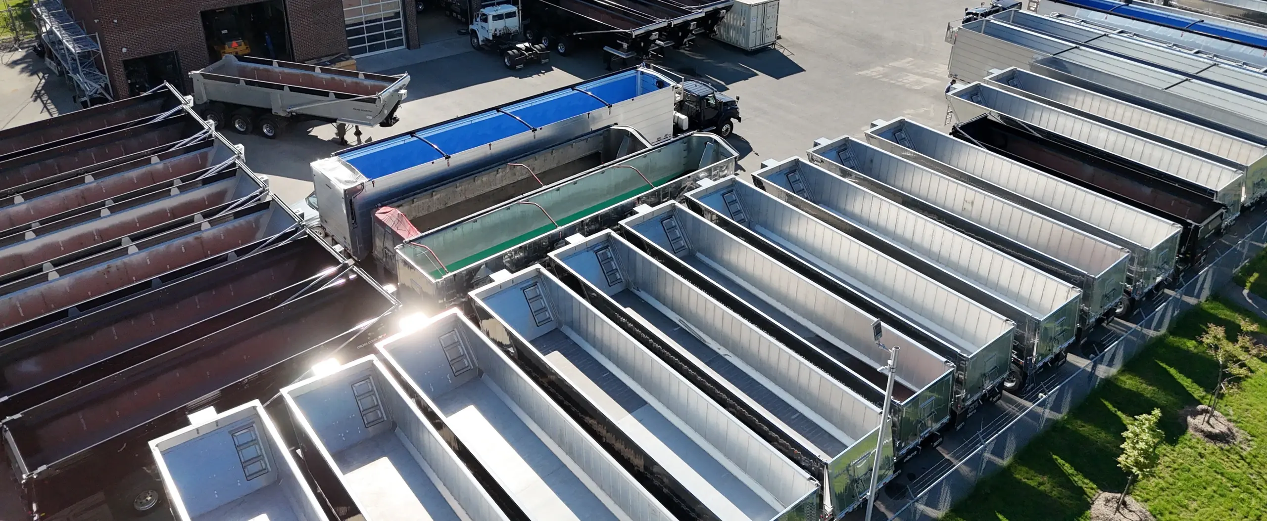 Bennes basculantes en aluminium alignées dans la cour, vues du ciel